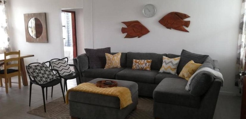 Living room with gray sectional and fish wall art