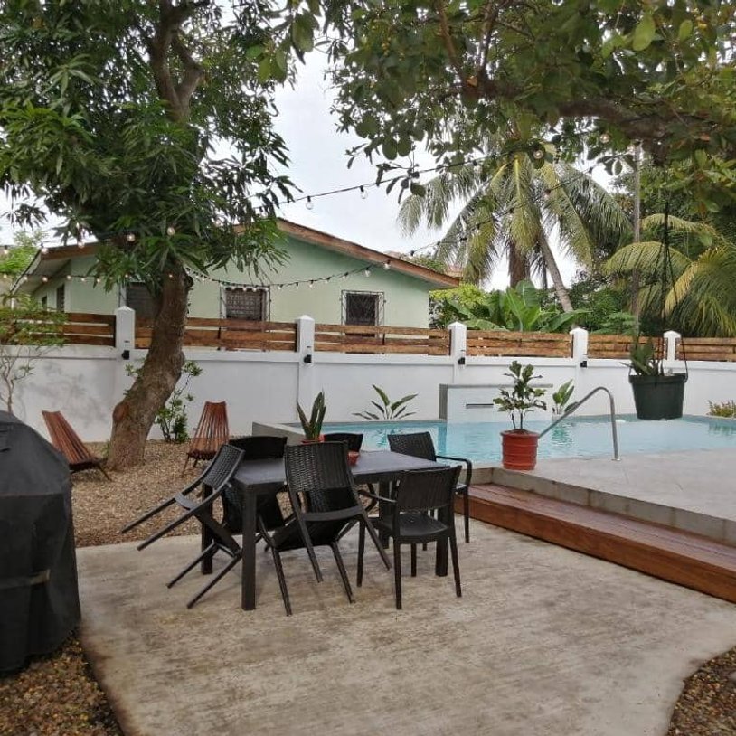 wide shot of the backyard. chairs, pool and bbq