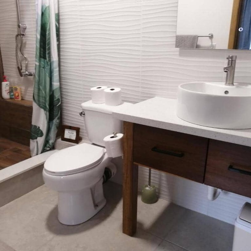 ensuite bathroom with a sink, toliet, and shower