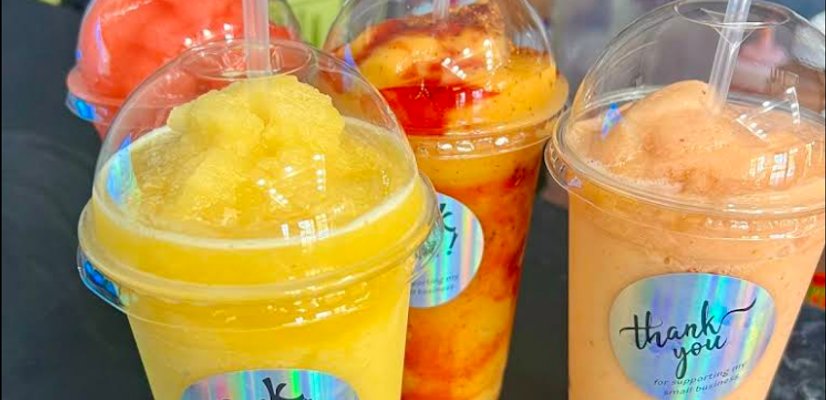 Colorful frozen slushies and iced drinks in clear cups with straws