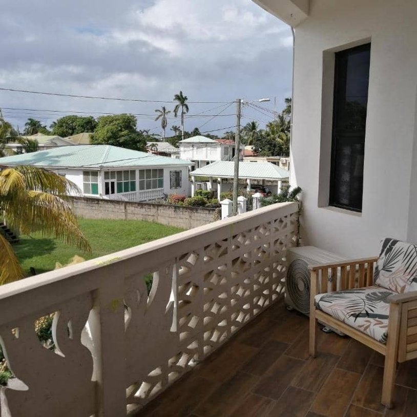 Balcony seating overlooking tropical residential neighborhood view