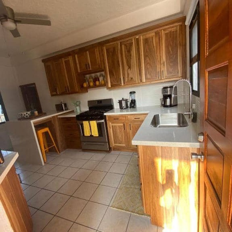 Fully stocked kitchen with stove, kitchen and fridge.
